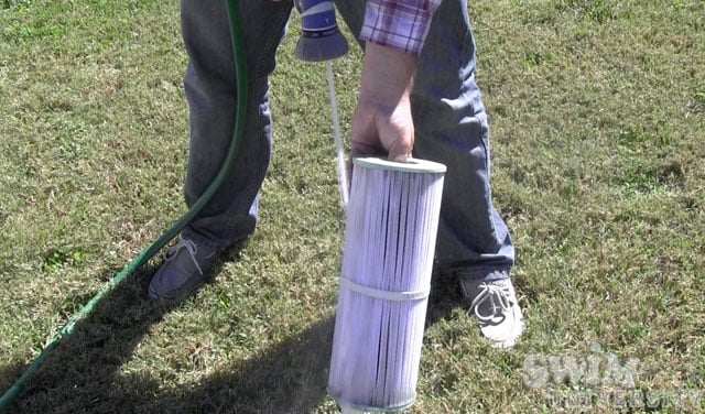 Rinsing your hot tub filter with a garden hose